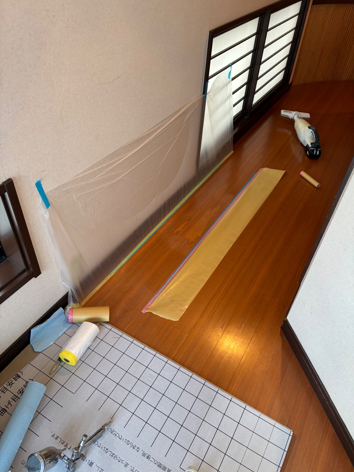 壁と窓枠を養生した作業中の床