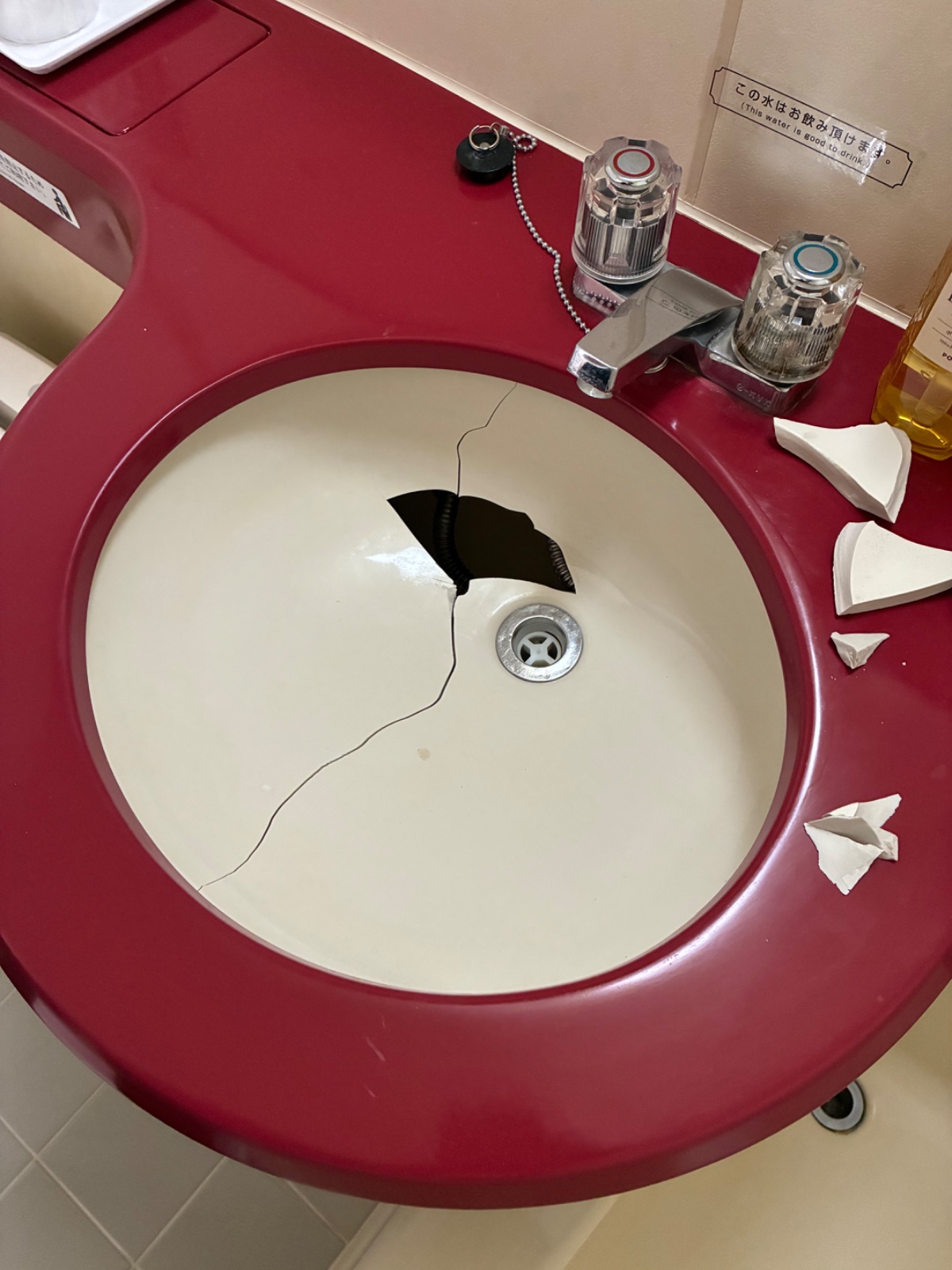 割れて中央に穴が開いた白い洗面ボウル
